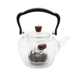 Clear glass teapot with black handle and lid knob with an internal measuring cup for defusing teas and herbs 